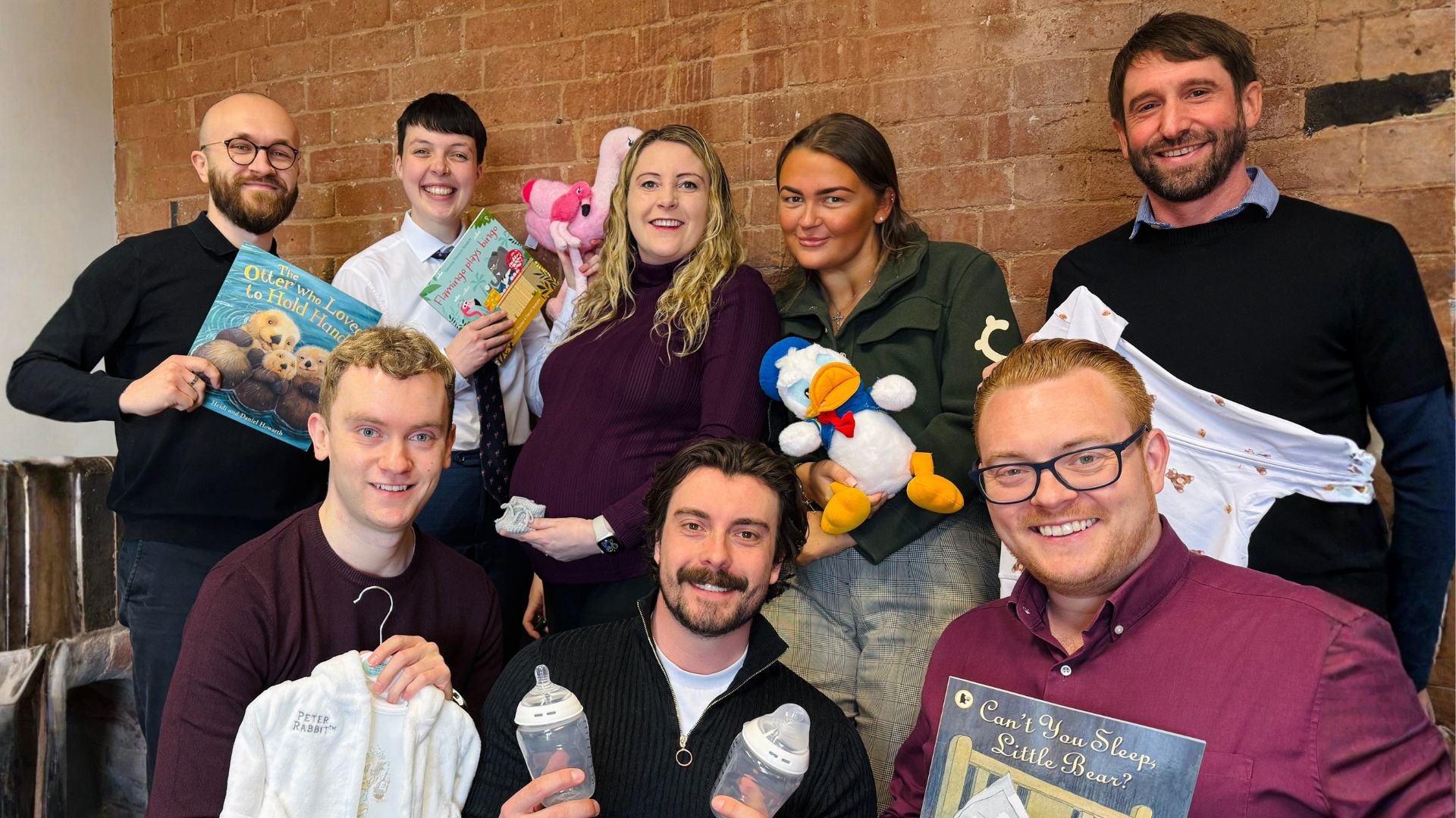 The Flamingo team taking a photo holding baby props.